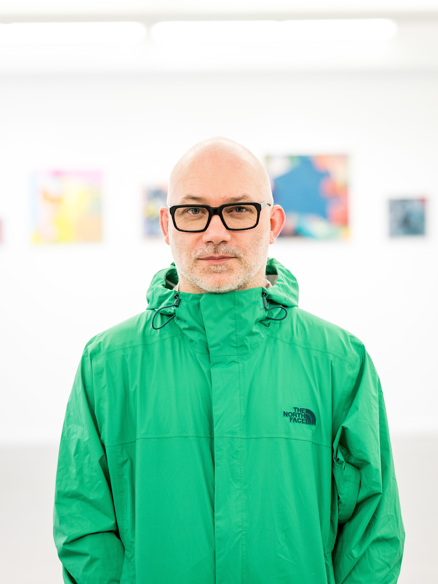 A photo of Gary Peters – a human wearing black framed glasses and a green waterproof jacket